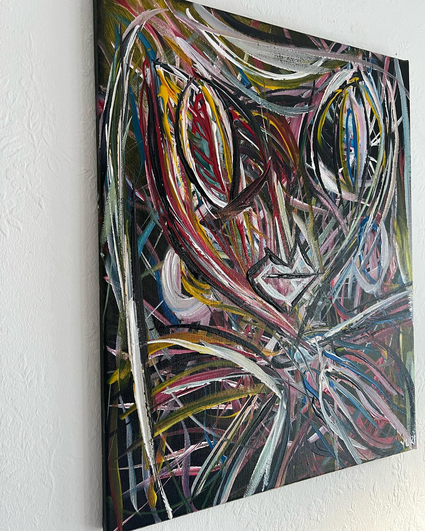 Abstract painting with multicolored brush strokes on a white wall