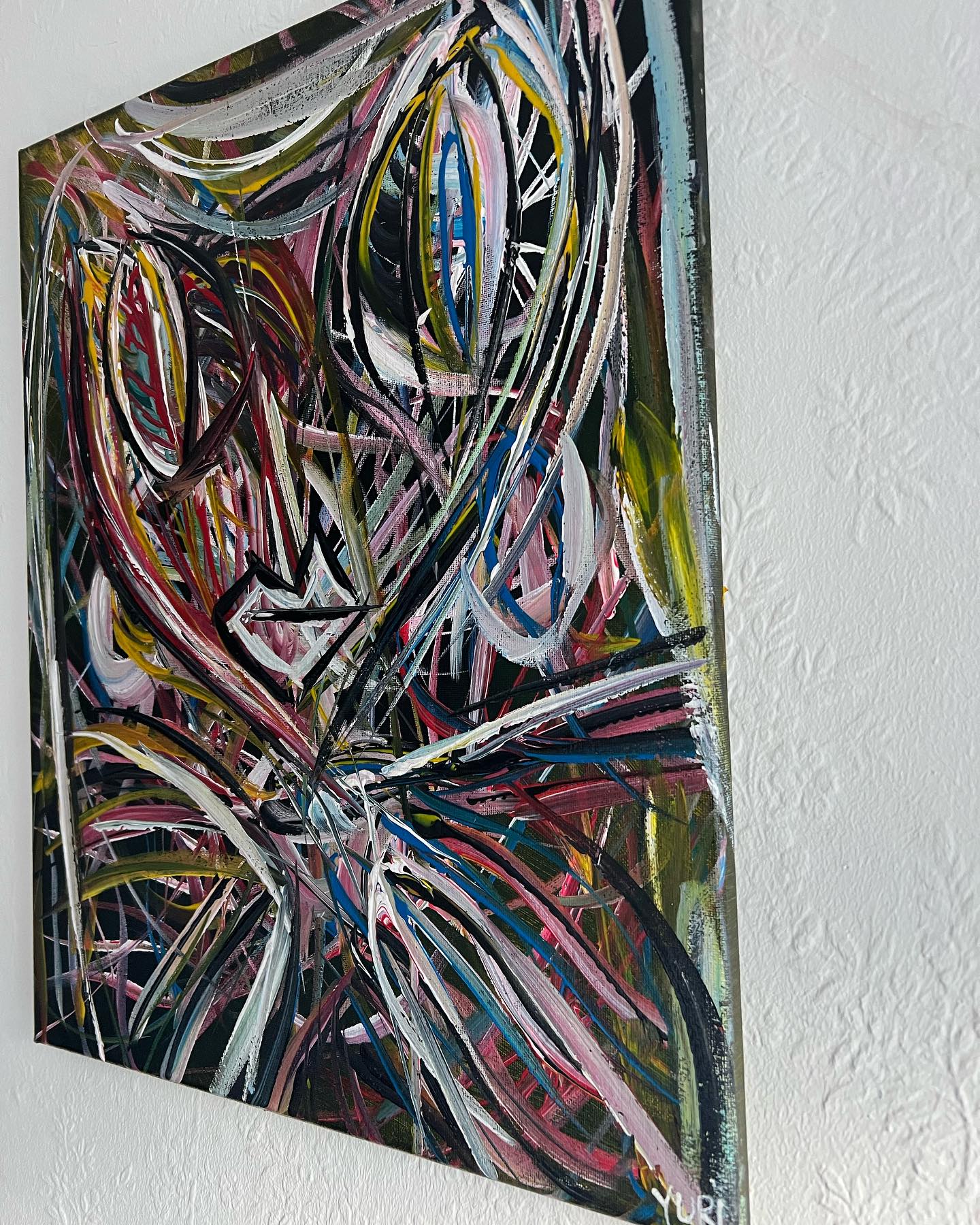 Abstract artwork with multicolored brush strokes on a white wall