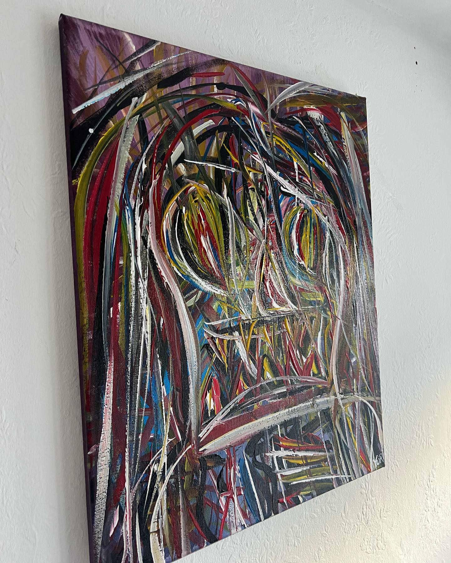 Abstract painting with multicolored brush strokes on a white wall