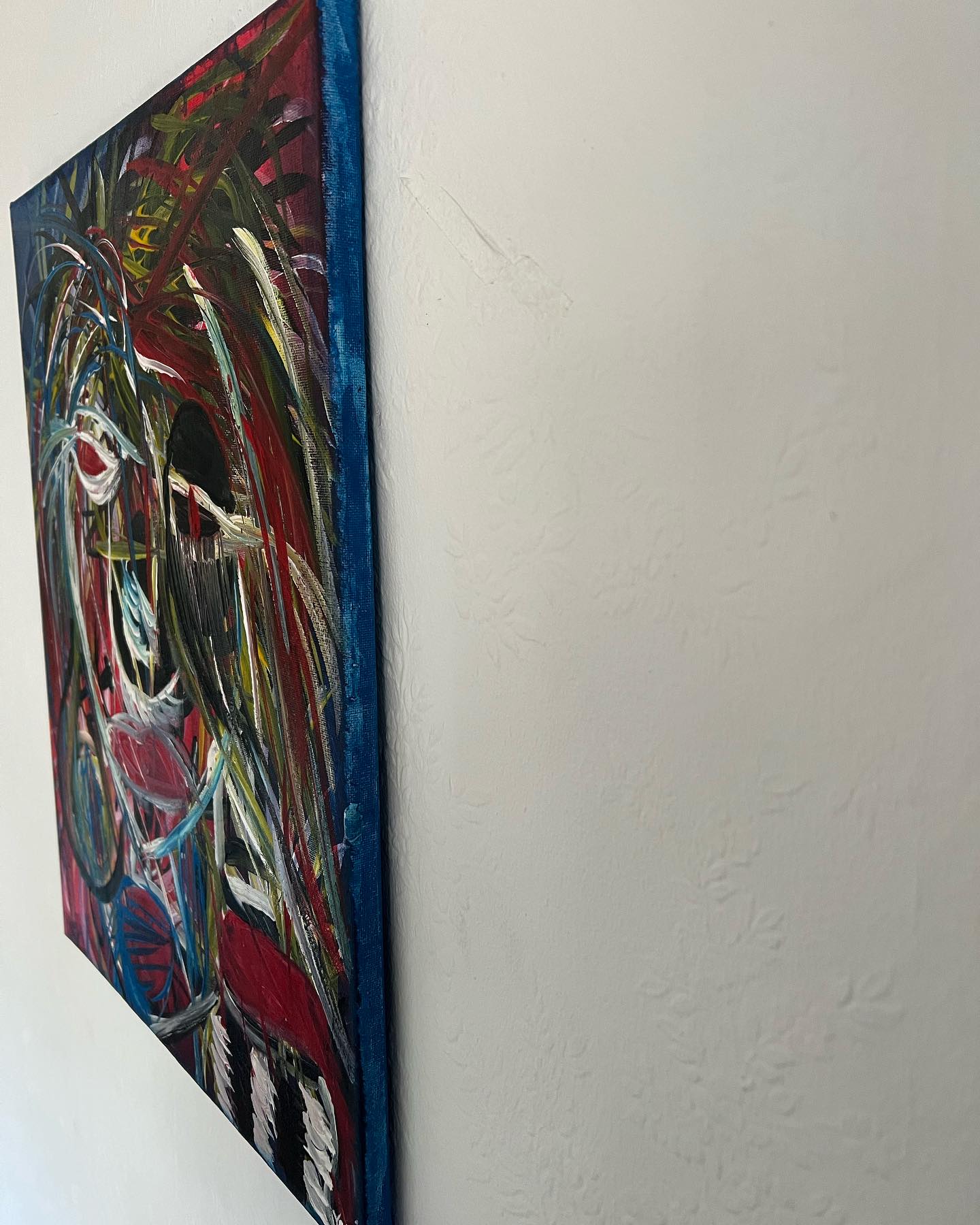 Abstract painting with vibrant colors on a white wall