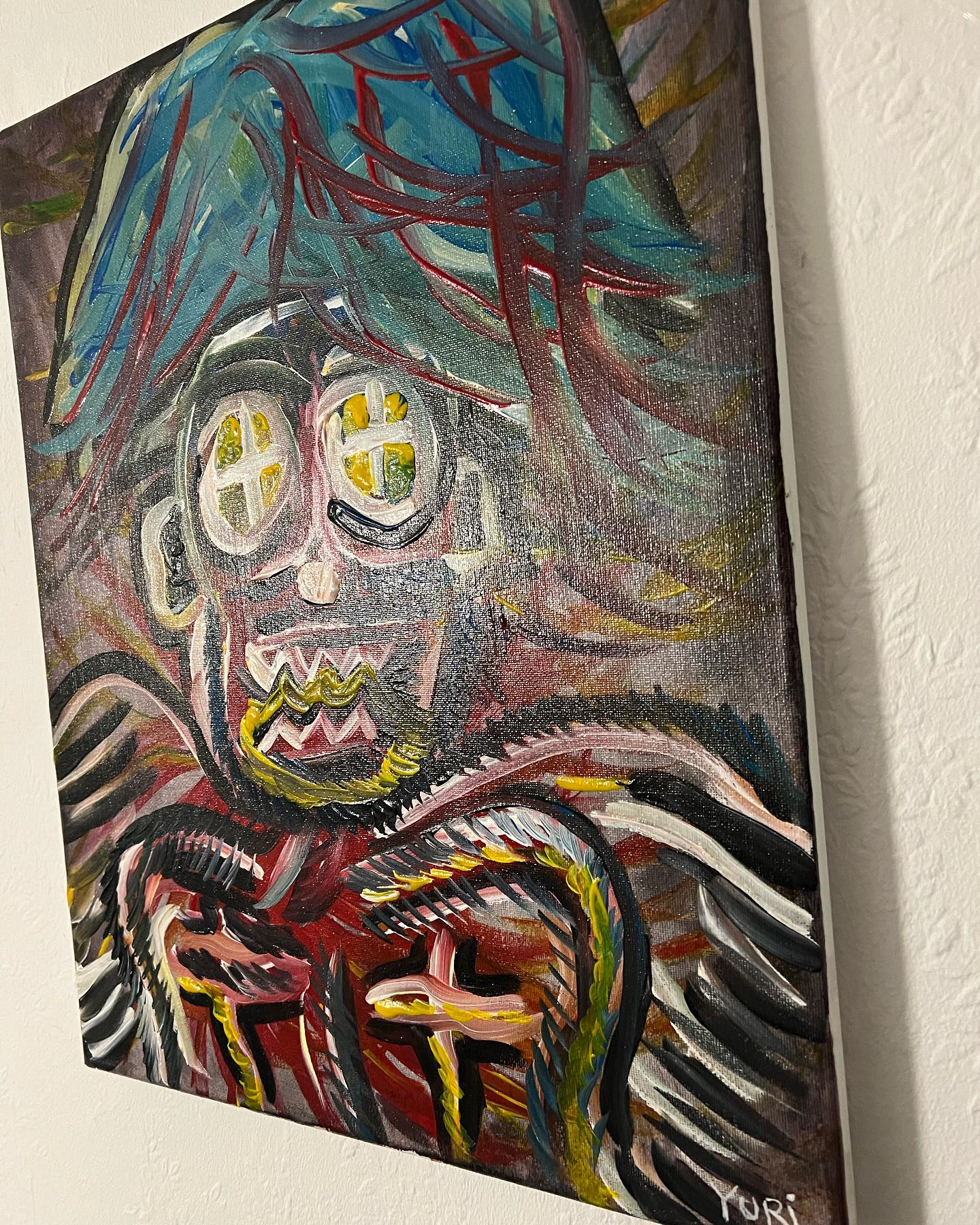 Abstract painting of a figure with exaggerated features on a white wall.